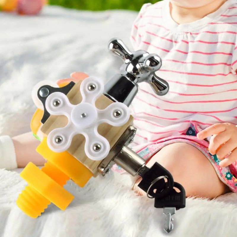 Bébé assis en extérieur sur une couverture, jouant avec le cube sensoriel 7 en 1